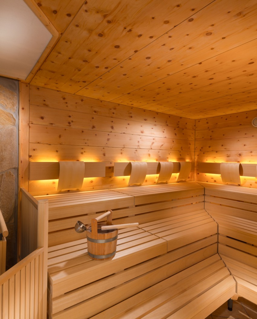 Entspanntes Paar in Badetüchern genießt die Sonne an der Wand der Bergheimat